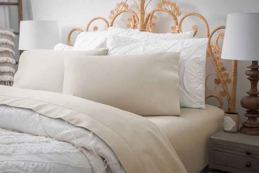 Image of bed with bedding in neutral colors, white, tan, and white. 