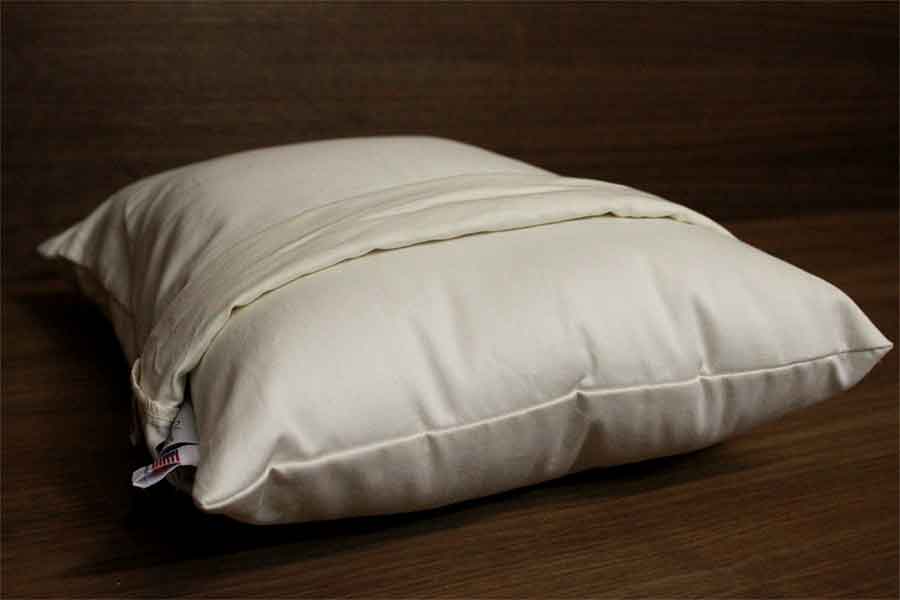 White pillow on dark wooden surface