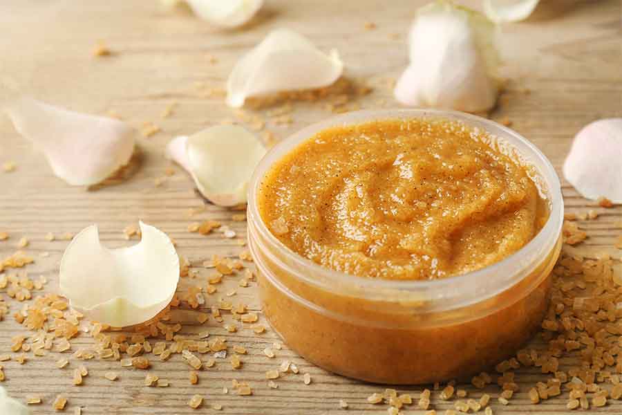 Image of Sugar Scrub on table with flower petals in the background