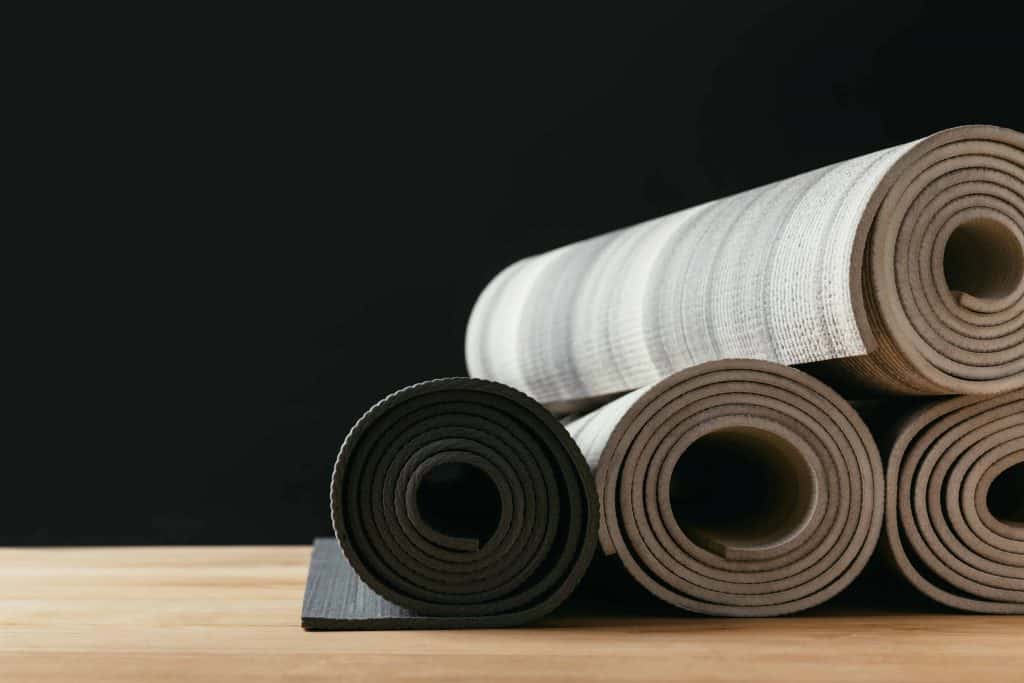 4 grey yoga non-toxic mats rolled up
