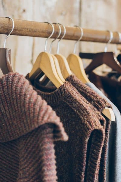 organic clothing brands on wooden hangers.