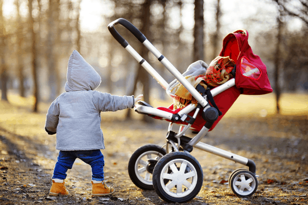 Little kid near red non-toxic stroller