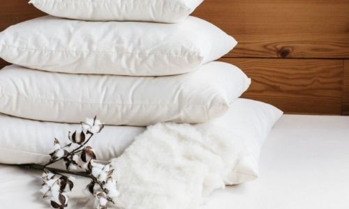 Holy Lamb Organics eco-friendly pillows stacked up on a bed