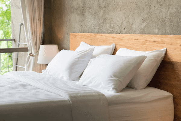 organic pillows on bed with wood frame