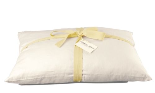 Soaring Heart organic pillow with a ribbon tied around it