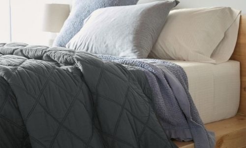 bed with a grey organic comforter on top