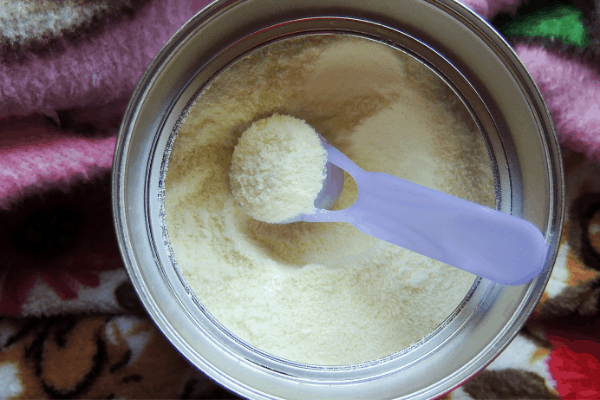 measuring spoon inside can of organic baby formula