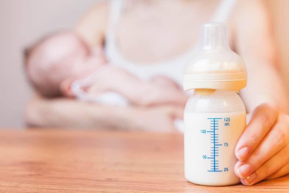 Mother holding baby and a baby bottle