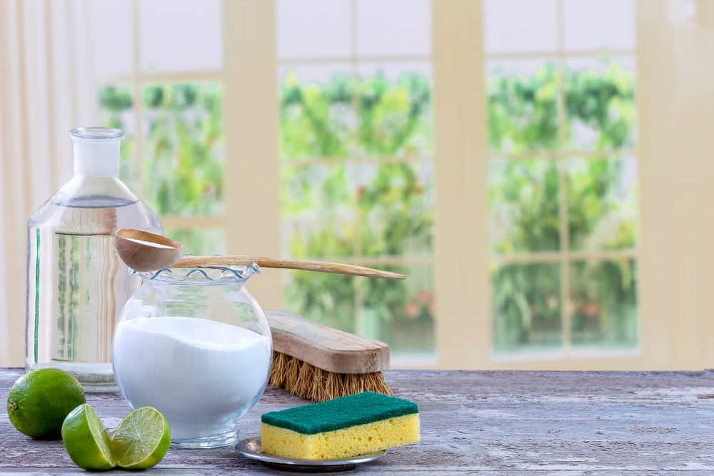 Natural cleaning supplies including baking soda, vinegar, and lime