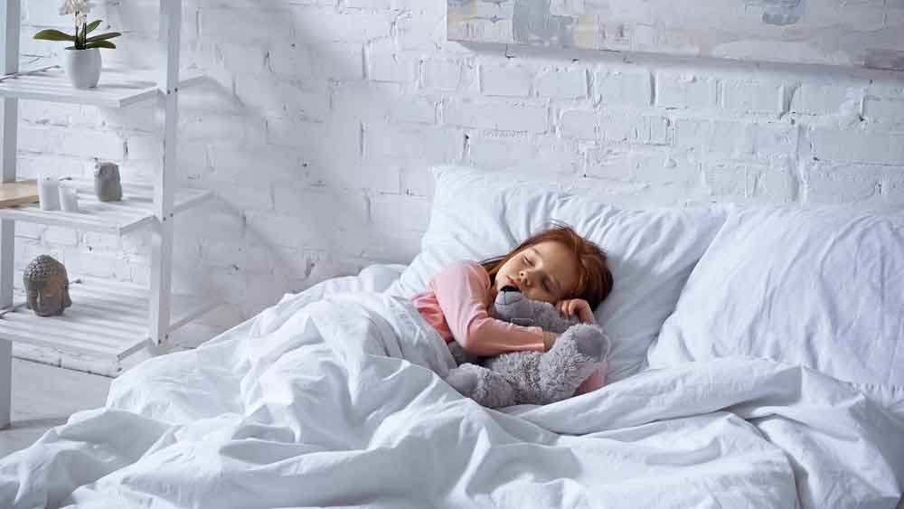 Girl sleeping in white bedsheet