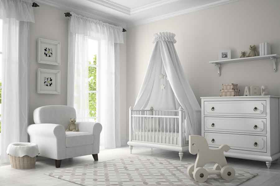Image of all baby nursery with all white furniture. Includes a crib, rocking horse, dresser, chair, curtains, shelf, and more