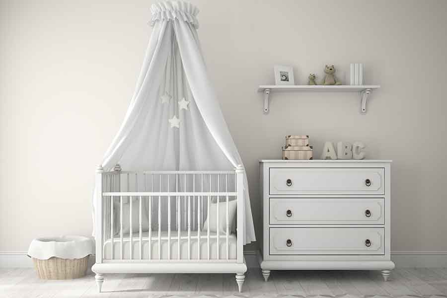 Image of a clean nursery with a dresser, crib, shelves, and more.