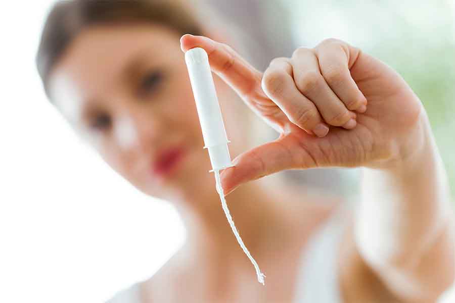 A woman holding onto a single tampon