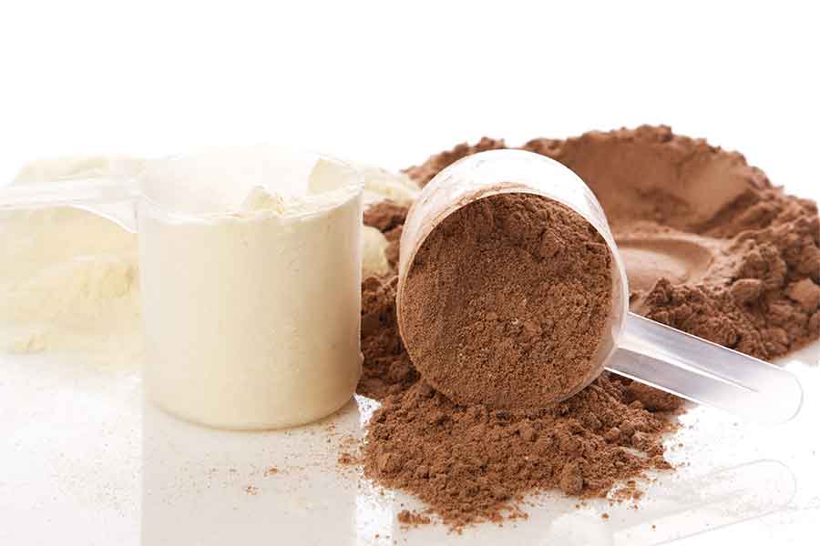2 scoopers filled with protein powder, chocolate and vanilla flavor on white background