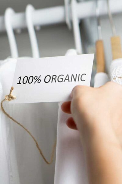 Sustainable Clothes Featured Image - Image of Clothing on a Rack with a Sign saying 100% Organic