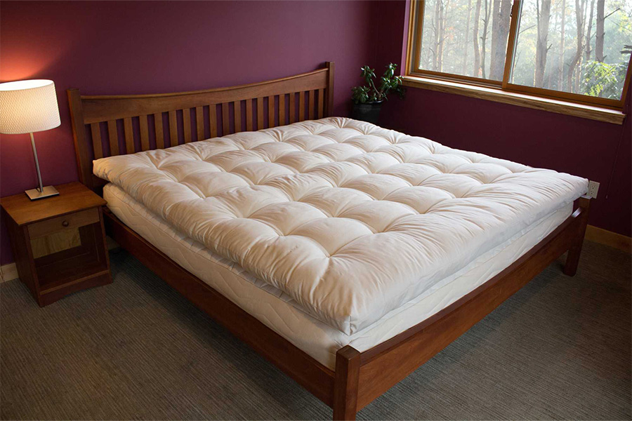 Holy Lamb Certified Organic Quilted Topper on Top of a Mattress and Wooden Bedframe